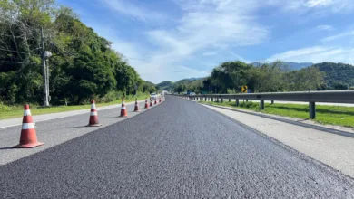 Equipe trabalhando na aplicacao de microrrevestimento asfaltico no pavimento da RJ-124, a Rodovia dos Lagos, que liga a Regiao Metropolitana a Regiao dos Lagos