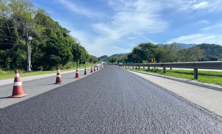 Equipe trabalhando na aplicacao de microrrevestimento asfaltico no pavimento da RJ-124, a Rodovia dos Lagos, que liga a Regiao Metropolitana a Regiao dos Lagos