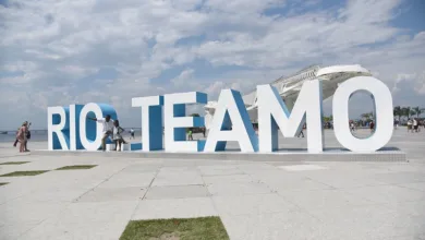 Letreiro "Rio Te Amo" com a orla e o Pão de Açúcar ao fundo, no Rio de Janeiro