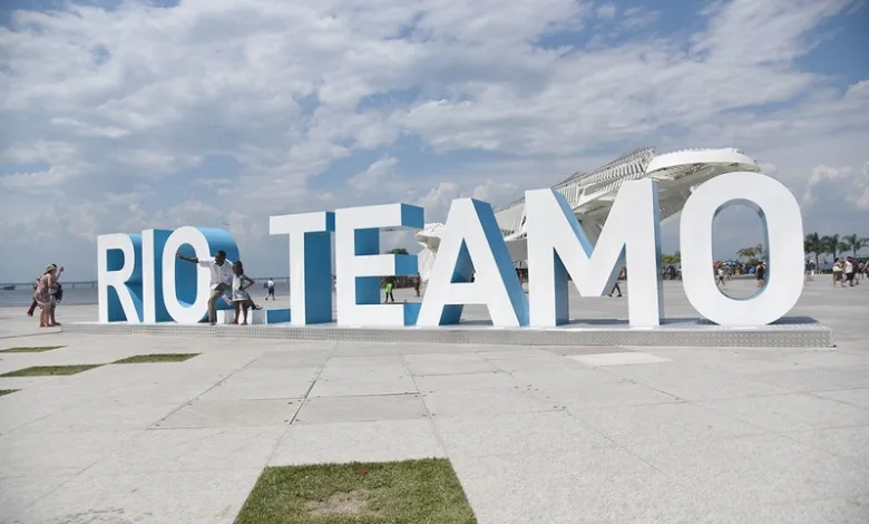 Letreiro "Rio Te Amo" com a orla e o Pão de Açúcar ao fundo, no Rio de Janeiro